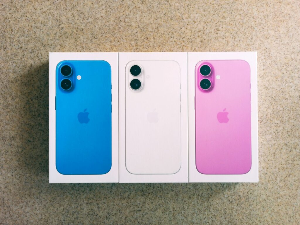 Three iphones in a box on the floor