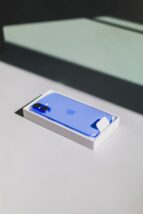 A blue iPhone sitting on top of a white table